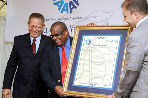 Rudolph Brown/Chief Photographer
Arnold J Foote, (right) president of the Advertising Agencies Association of Jamaica, presents the award for media Personality of the year to Lloyd B Smith, looking on at left is Prime MInister Bruce Golding at AAAJ Media Awards 2009  at Knutsford Court Hotel  New Kingston. on Wednesday, June 10-2009
