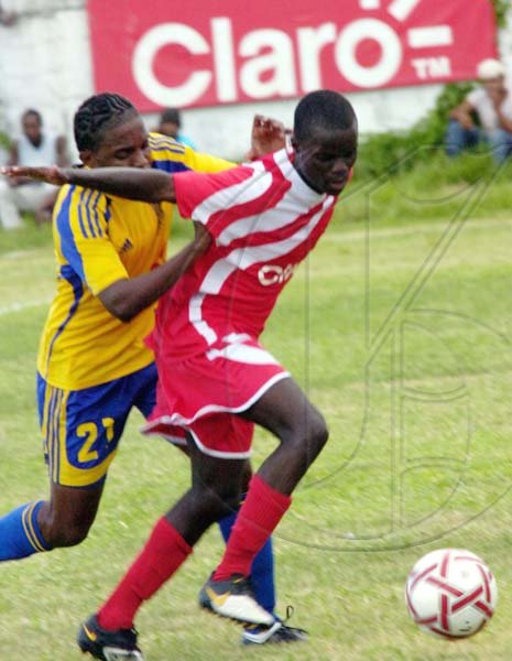 Norman Grindley/Chief Photographer
Boys Town's Marvin Morgan shields the ball from Harbour View's Daveion Woodhouse during their Claro Champion League game yesterday at Collie Smith Drive. Boys Town won 3-1.