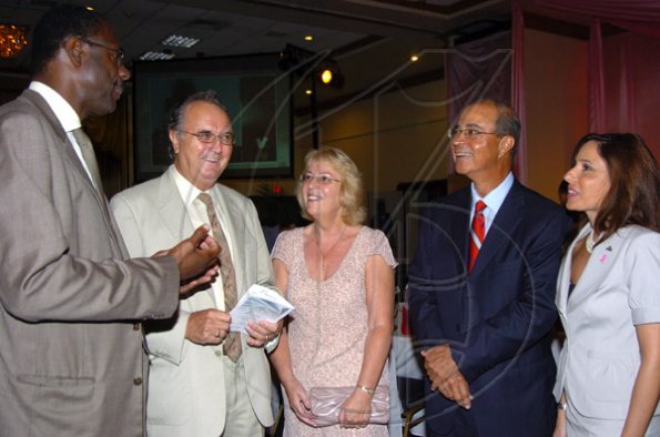 Peta-Gaye Clachar/Staff Photographer
Jamaica National Building Society Executive Mr. Emile Spence (left) grabs the attention of Director of the Jamaica Cancer Society Mr. Lawrence Stewart with his wife Elin, Vice Chairman of the Jamaica Cancer Society Mr. Michael Fraser and Tara Nunes from PanCaribbean in a group discussion at the Jamaica Reach to Recovery "Keeping with Breast Cancer" luncheon at the Jamaica Pegasus on Thursday, October 22, 2009.