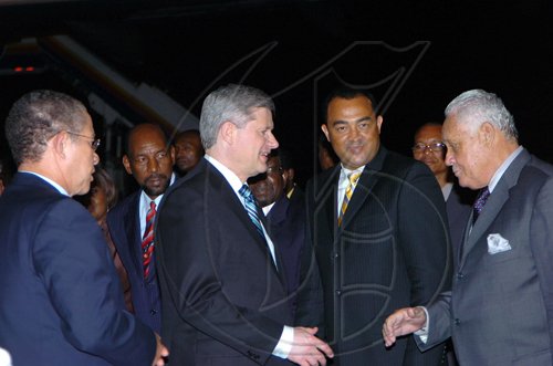 Rudolph Brown/Chief Photographer
Prime Minister Bruce Golding (secon left) welcomes Canadian Prime Minister Stephen Harper, (centre) to Jamaica shortly after both leaders landed at the Norman Manley International Airport yesterday. Harper and Golding  were returning from the Fifth Summit of the Americas which was held in Trinidad and Tobago. Harper is on an official visit to Jamaica.