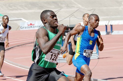 Ian Allen/Staff Photographer
Calabar's Travis Drummond (left) powers down the straight to win his Class Two boys 200m preliminary round heat in yesterday's opening day of the GraceKennedy Boys' and Girls' Athletics Championships at the National Stadium.