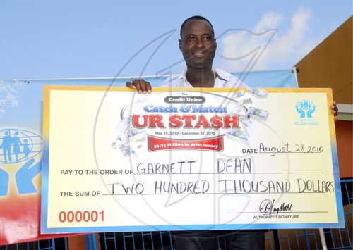 Garnett Dean posing with his cheque representing his winnings.