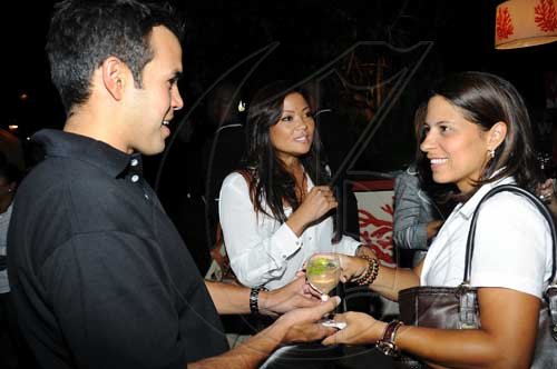 Rudolph Brown/Photographer
Andrew Matalon of Scotia DB&G serves Tina Myers-Matalon (right) of KFC as Krystal Chong , director of marketing for Honey Bun, at the Wealth Magazine and Scotia DBG Investments Chicks and Balances  party.

**************************************************************************** at Terra Nova Hotel in Kingston on Thursday, August 19-2010
