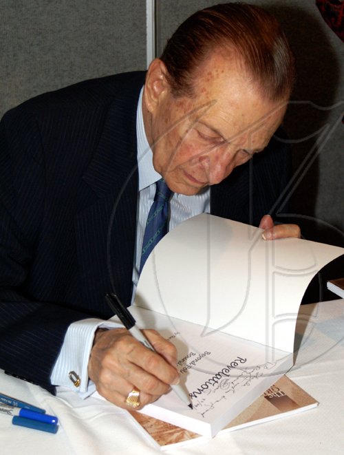 Contributed
Former Prime Minister Edward Seaga signs copies of his books at the launch.