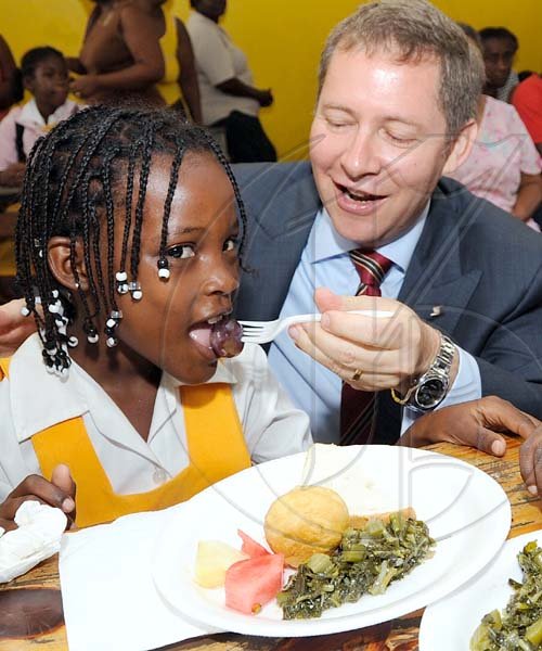 Rudolph Brown/Chief Photographer
Bruce Bowen, President and CEO Scotiabank feeds Natasha Four, at the ScotiaFoundation Breakfast Feeding Programme launch, Scotiabank feed 30 children at the Whitfield All Age School, 20 Whitfield Ave. in Kingston on Wednesday, May 27-2009, Scotia Foundation supports a Breakfast Feeding Programme for 600 Kids in five (5) schools across Jamaica at a cost of $2million.  The schools include Bamboo Primary and Junior High, St. Ann, Holy Family Primary and Infant School, Kingston,  Whitfield All Age School, Kingston, Drapers All Age School, Portland and Norwich Primary, Portland.