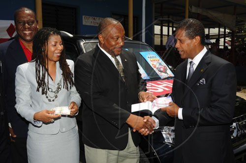 Ian Allen/Staff Photographer
Neville Atkinson (second right) president of the Kiwanis club of North St Andrew presents chairman of the South-East Regional Authority, Lyttleton Shirley (right) with a raffle book while Beverly Needham CEO of the hospital  waits to make her purchase and Neville Richards representative of Motor Sales and Service Company Ltd looks on. This takes place at the Kiwanis Club of North St. Andrew launch of the 2009 fund raising event at the Bustamante Hospital for Children.