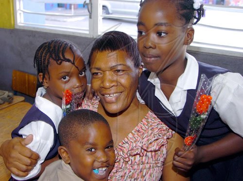 Rudolph Brown/Chief Photographer
Ivorine Thompson, receive roses from her students Kimmani Barrett, (right) Makenna Smith, (left) and Taravi Thomas on Teachers Day, at Windward Road Primary and Junior High at 141 Windward Road in Kingston on Wednesday May 6-2009.