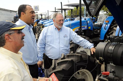 Rudolph Brown/Chief Photographer
Stephen Henriques, (left) Director of Sales and Philip Henriques, (right) Managing Director of Kingston Industrial Agencies show Christopher Tufton, (centre) Minister of Agriculture and Fisheries before handing over the 10 four cylinder tractor to the minister for the Rural Agricultural Development Authority (RADA) to modernize the agricultural sector, a contract valued at some $30.2 million was awarded to Kingston Industrial Agency, the tractors will be dispatched islandwide to assist farmers in land preparation, the hand over ceremony took place at the Kingston Industrial Agency on Wednesday, June 3-2009
