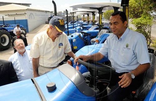 Rudolph Brown/Chief Photographer
Stephen Henriques, (centre) Director of Sales and Philip Henriques, (left) Managing Director of Kingston Industrial Agencies show Christopher Tufton, (right) Minister of Agriculture and Fisheries before handing over the 10 four cylinder tractor to the minister for the Rural Agricultural Development Authority (RADA) to modernize the agricultural sector, a contract valued at some $30.2 million was awarded to Kingston Industrial Agency, the tractors will be dispatched islandwide to assist farmers in land preparation, the hand over ceremony took place at the Kingston Industrial Agency on Wednesday, June 3-2009