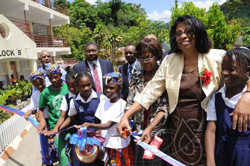 Ricardo Makyn/Staff Photographer.
From left behind School Children E.G.Barrett O.D.JP with Principal Winston Jackson and Reverend Phillip Robinson looks on asThe  Most Honourable Lorna Golding Wife of the Prime Minister  and Goldie Flaconer-Simpson Justice of the Peace Cut the Ribbon  at the Ceremony for the openning and renaming of the Gordon Town All Age School to the Louise Bennett-Coverley All Age on Thursday 4.6.2009.