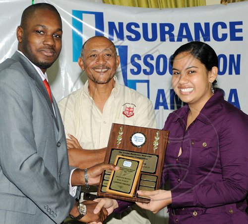 Rudolph Brown/Chief Photographer
Nikolaus Price, (left) of Sagicor Life Jamaica presents Janille Maragh, and her math teacher Kesang Chinstudent of Campion College with all Island Champion School, Insurance Association of Jamaica, Vivian Rochester Memorial Mathematics competition top trophy at the Hilton Hotel in New Kingston on Friday, June 5-2009.