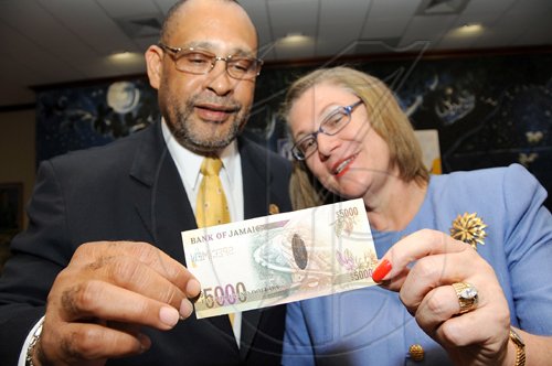 Rudolph Brown/Chief Photographer
Derick Latibeaudiere, Governor of BOJ look at $5000 Banknote with Professor Denise Eldemire-Shearer after presents the note to her at the launch of the $5000  Banknote bearing Former Prime Minister Hugh Shearer at the Bank of Jamaica in Kingston on Monday , May 18-2009.