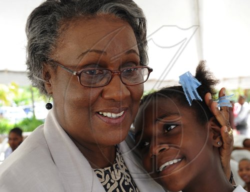 Ricardo Makyn/Staff Photographer.
Mary Clarke Childrens Advocate gets a hug from Shantel Thomas a Student of Alpha Primary at the openning Ceremony for the Ministry of National Security Childs Montha Exhibition and Panel Discussion at 2 OxFord Road at the NCB Towers on Monday 18.5.2009.