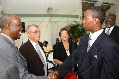 Ricardo Makyn/Staff Photographer.
Left Dr Gilbert Allen,Custos of Clarendon R James de'Roux  and Rev.The Hon.Mrs Sophia Azan,CD,JP Custos of St Catherine with  Glendon Lewis Junior winner of the United Jamaica Alumni Association Essay Competition in America and Who's trip to Jamaica  was sponsored by Jamaiaca National Building Society while in the background is Glendon Lewis Senior  the occasion was the  Governor General's Consultative Youth Breakfast at the Caymanas Golf Club on Friday 15.5.2009.