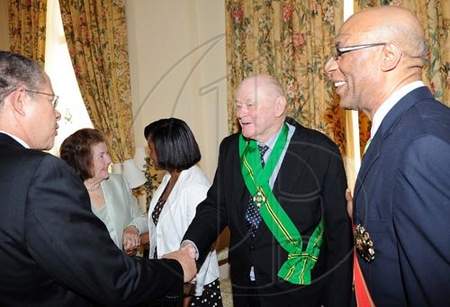 Rudolph Brown/Chief Photographer
Prime Minister Bruce Golding congratulated Desmond Blade after the Governor General Dr. Patrick Allen, (right) invested the Order of Jamaica on Mr. Blade during a ceremony of investiture and presentation of National Honours and Award at Kings House, St Andrew on Tuesday. May 12-2009 chatting in back are Peggy Blade, (second left) wife of Desmond Blade and Patricia Allen wife of the Governor General.