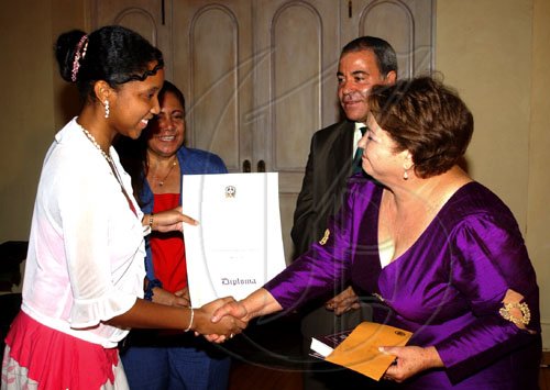 Winston Sill / Freelance Photographer
Kerry-Ann Mew (left) receives the second place prize from Dominican Republic Ambassador Filomena Navarro (right). Looking on are Luisa Navarro (second left) and Avelino Stanley.

 presents the Professor Juan Bosch Short Story Gala Awards, in celebrating his centenary, held at King's House Hope Road on Tuesday June 30, 2009.