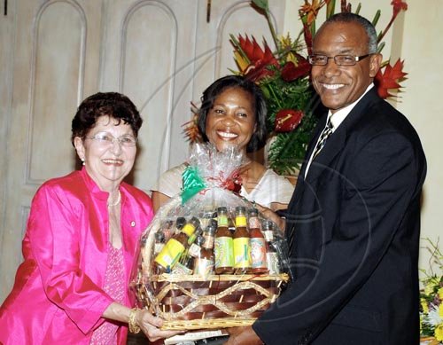 Colin Hamilton/freelance photographer
Businesswoman and memmber of The Gilbert and Georgia Allen Educational Trust (left), is assisted by Michael Anthony Cuffe, master of ceremonies for the event, in making a presentation  to Lady Allen, wife of the Governor General.

*****************************************************************************launch at Kings House on Thursday March 25, 2010.