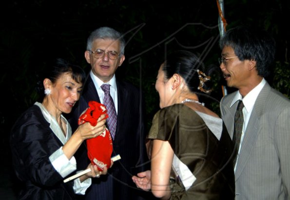 Winston Sill / Freelance Photographer
Shumei Tanaka (right) and Tomoko Tanaka present a gift to Fiela Mazzocchi Alemanni while husband Marco looks on.

and Fiela Mazzocchi Alemanni host Europe Day Reception, held at Hyperion Avenue, Jacks Hill on Wednesday night May 12, 2010.