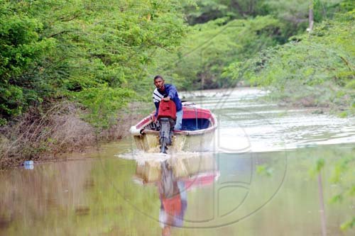 Norman Grindley/Chief Photographer
A boater makes his way down a flooded street in Milk River, Clarendon, after heavy rains pounded the area on Monday. 

May 25, 2009.