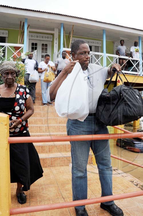 Norman Grindley /Chief Photographer
Guests leave the Milk River Hotel and Spa in Clarendon after being marooned. 

it was flooded out yesterday.