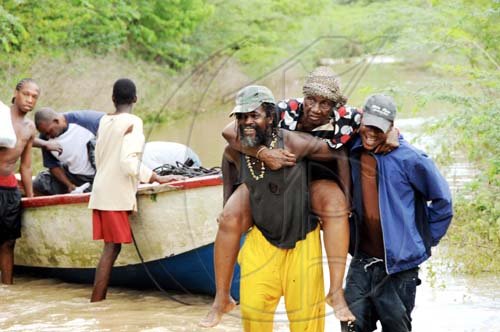 Norman Grindley/Chief Photographer
A guest at the Milk River Hotel and Spa in Clarendon gets a piggy-back ride after being transported by a boat.