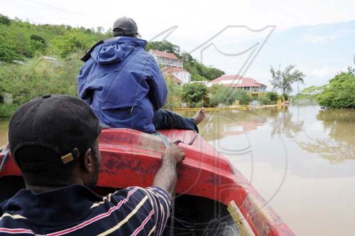 Norman Grindley/Chief Photographer
A passenger  on a boat points to a flooded street.


 by the  Milk River hotel and Spa in Clarendon after it was flooded out by heavy rain May 25, 2009.