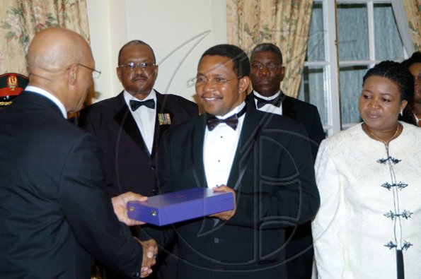Winston Sill/Freelance Photographer
Governor General Sir Patrick Allen (left) presents Tanzanian President Jakaya Mrisho Kikwete with the Order of Excellence, Jamaica's highest award to a foreign head of state. Looking on is Salma Kikwete, the president's wife. In background from left are Major General Stewart Saunders and Acting Commissioner of Police Owen Ellington.

dinner held in honour of the President of Tanzania, Jakaya Mrisho Kikwete at Kings House on Wednesday November 25, 2009.