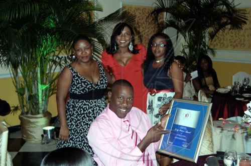 N’Kem Gordon showing off his award. Other Intcomex employees are (from left): Keisha Lawla, Janice Morris and Suzette Hooper.