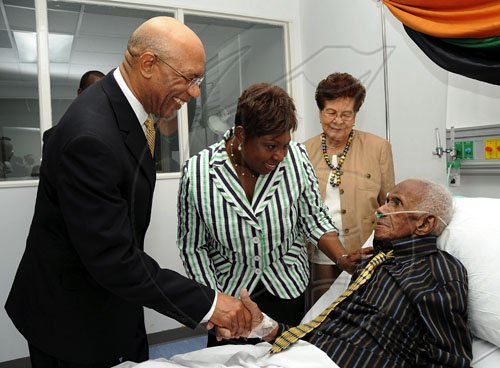 Ian Allen/Staff Photographer
Sir patrick Allen left, Governor General could not hide his delight when met Wycliffe Bennett right just before he was presented with a Musgrave Gold Medal at an award ceremony at the University of the West Indies Hospital. Wycliffe Bennett who has been ailing for some time was also visited by Olilvia Grange second left, Minister of Youth, Sports and Culture and his wife Dr. Hazel Bennett second right.