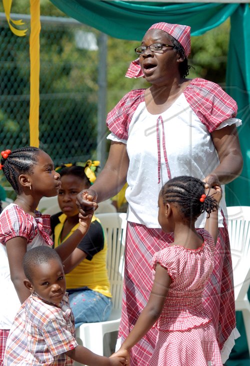 Ricardo Makyn/Staff Photographer.
Teacher Sherel Johnson of the ST Marks Anglican Church with Students from left Tashai Witter Omar Plumber and Shanae Mais at the Craighton Primary School  in the Red Light District in Rural St  Jamaica Day on Friday 25.2.2011.