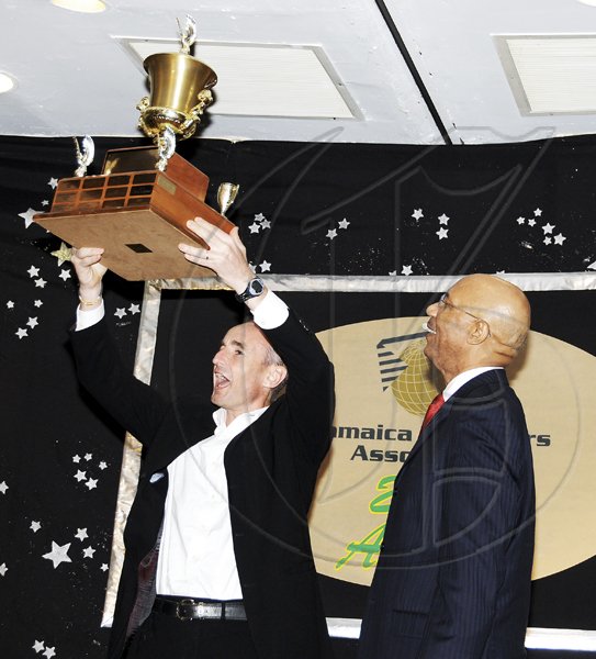 Winston Sill / Freelance Photographer
Jamaica Exporters Association (JEA) Awards Banquet, held at the Wyndham Hotel  on  Wednesday night June 29, 2011. Here Allan Barnes (left), outgoing Managing Director of Red Stripe hold aloft the Champion Exporter Trophy. Looking on is Governor General Sir Patrick Allen (right).