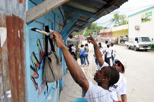 Ricardo Makyn/Staff Photographer.
These people do Labour Day work on this shop  in Riversdale, St Catherine yesterday.
