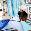Ricardo Makyn/Staff Photographer.
A Young Lady Who's in the National Youth Service Paints a section of this Bar  in Riversdale on Labour Day in St Catherine on Monday 25.5.2009.