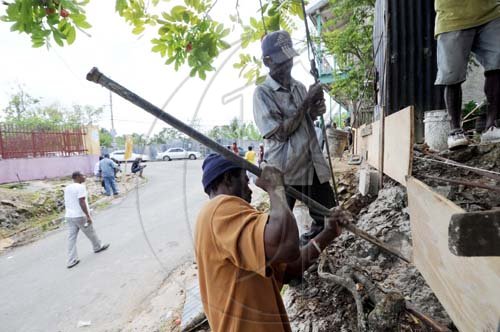 Ricardo Makyn/Staff Photographer.
Labour Day Volunteers build a Wall on the Gobay main road  in St Catherine yesterday.