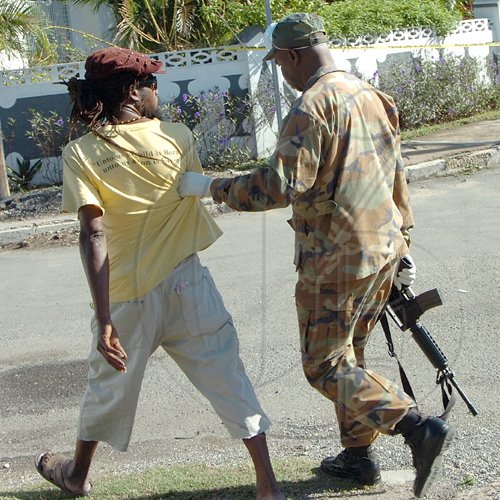 Rudolph Brown/Chief Photographer
A solider arrested a man at Luciana House after a two hour shoot out at the artiste's home with a lone gunman, three policemen were shot and injured at Westminster Crescent in St. Andrew on Wednesday, March 25-2009