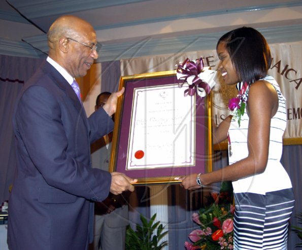 Peta-Gaye Clachar/Freelance Photographer
Governor General of Jamaica Honourable Sir Patrick Allen present the Youth Musgrave Award and citation to Miss courtney Foster for her contribution to Community service at the Institute of Jamaica (IOJ) Musgrave Awards ceremony at IOJ on Wednesday, October 14, 2009.