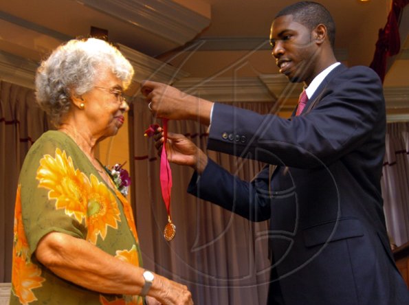 Peta-Gaye Clachar/Freelance Photographer
Senator Warren Newby representing the Minister of Youth, Sports and Culture Honourable Olivia Babsy Grange presents Mrs. Jean Smith with a silver medal for her contribution to Arts Administration at the Institute of Jamaica (IOJ) Musgrave Awards ceremony at IOJ on Wednesday, October 14, 2009.