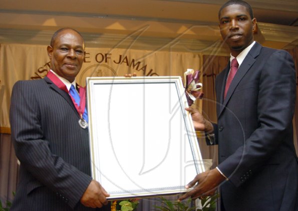 Peta-Gaye Clachar/Freelance Photographer
Senator Warren Newby representing the Minister of Youth, Sports and Culture Honourable Olivia Babsy Grange presents Professor Gossett Oliver with a silver medal and citation for his contribution to Engineering at the Institute of Jamaica (IOJ) Musgrave Awards ceremony at IOJ on Wednesday, October 14, 2009.