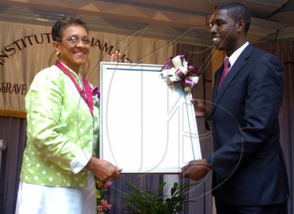 Peta-Gaye Clachar/Freelance Photographer
Senator Warren Newby representing the Minister of Youth, Sports and Culture Honourable Olivia Babsy Grange presents Mrs. Paulette Bellamy with a silver medal and citation for her contribution to Music at the Institute of Jamaica (IOJ) Musgrave Awards ceremony at IOJ on Wednesday, October 14, 2009.