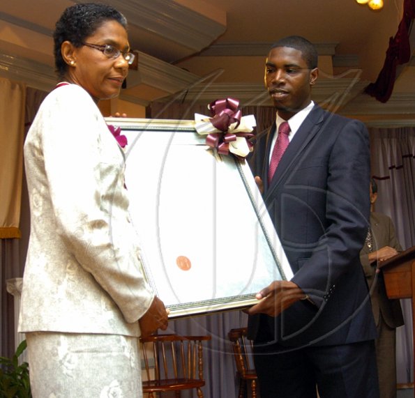 Peta-Gaye Clachar/Freelance Photographer
Senator Warren Newby representing the Minister of Youth, Sports and Culture Honourable Olivia Babsy Grange presents Professor Helen Jacobs with a silver medal and citation for her contribution to Organic Chemistry at the Institute of Jamaica (IOJ) Musgrave Awards ceremony at IOJ on Wednesday, October 14, 2009.