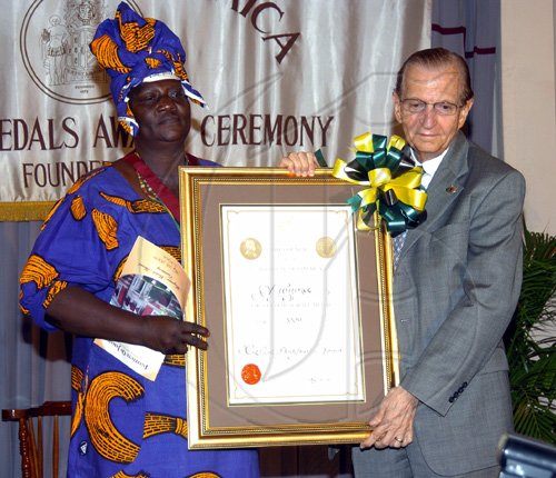 Peta-Gaye Clachar/Staff Photographer
Former Prime Minister of Jamaica and Fellow of the Institute of Jamaica the Right Honourable Edward Seaga presents a musgrave gold medal and citaion to Miss Bernice Henry for her contribution to Kumina in literature Science and the Arts at the Institute of Jamaica Musgrave Medals Awards Ceremony at the Institute of Jamaica on Thursday, May 28, 2009.