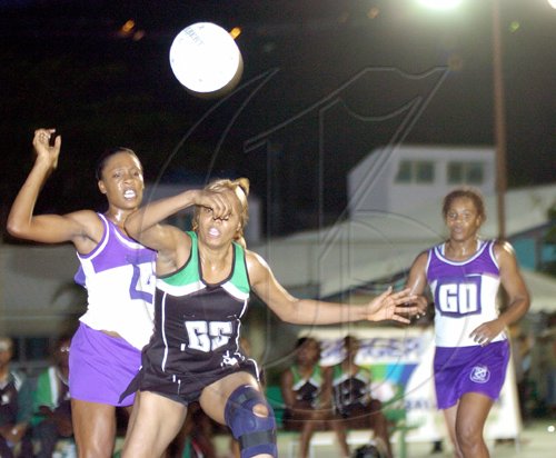 Peta-Gaye Clachar/Staff Photographer
Jamalco's Goal Shooter Elaine Davis (centre) and Waulgrovians Goal Keeper, Yanique Gordon (left), challenge for the ball while Waulgrovians Goal Defence, Oberon Pitterson reacts during Game Two of the JNA/Berger Paints Super League netball final at the Leila Robinson Stadium on Saturday. Jamalco won 50-46 to tie the three-game series 1-1.