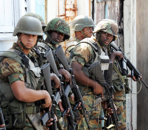 Norman Grindley /Chief Photographer
Jamaica Defence Soldiers use a fence for a shield as they prepare to enter the fray, as police and gunmen locked horns in Hannah Town, West Kingston on Monday.







West Kingston riot, March, 15, 2010.