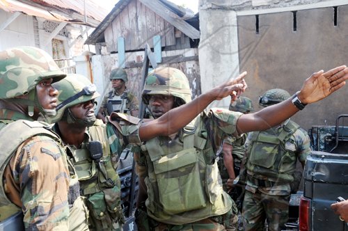 Norman Grindley /Chief Photographer
These Jamaica Defence Force soldiers point to the direction guns shots come from during an operation in West Kingston on Monday.