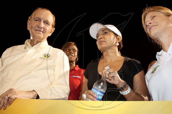 Contributed
Former Prime Minister Edward Seaga, gives us a quick smile before joining Flow president and COO Michelle English (right) and Public Relations Manager, Denise Williams, in presenting the big cheque to the Flow's Champion's Cup's winning team, Boy's Town.