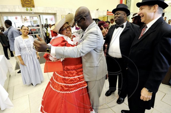 Rudolph Brown/Photographer
Mayor of Kingston Desmond McKenzie dances with Joan Badson Mignott while Bruce Bowen (right), president and CEO of Scotiabank Group Jamaica and Michael Shaw (second right), Scotiabank Kings Street branch manager, look on as Scotiabank celebrates 120 years in Jamaica at the Kings Street Branch, downtown Kingston yesterday. To mark the occassion, everyone wore vintage clothing from the 1880s.