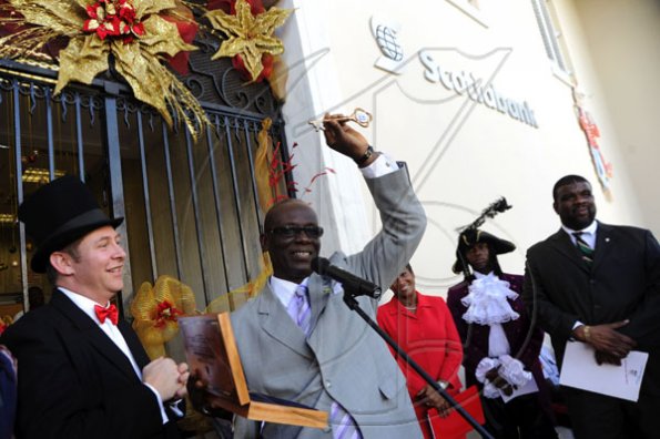 Ricardo Makyn/Staff Photographer.
Left Lef Bruce Bowen President and CEO ScotiaBank looks on as Mayor of Kingston and St Andrew Desmond Mckenzie holds aloft the Keys to the City before presenting it to Scotia Bank at the King Street Branch while lookin on are Heather Gordon Vice Preseident Public and Corporate Affairs with costumed participant in the parade and Town Clerk Errol Greene at the presentation Ceremony on King Street on Monday 14.12.2009.
