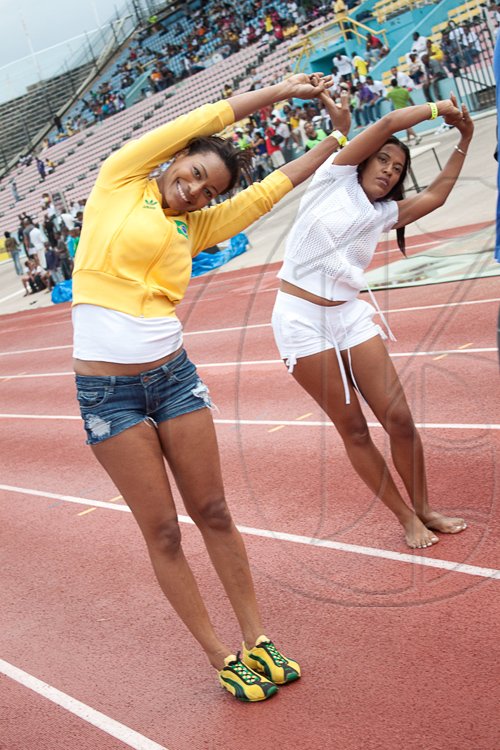 Warming up has never looked so cute! Tanya Lee, (left) Regional Marketing Manager for SportsMax Limited, does a winning stretch along with Amelia 'Milk' Sewell, shortly before taking the gold in the female corporate 100m sprint at Ash Wednesday's Bob Marley One Love Charity Celebrity Football Matches and Celebolympics.