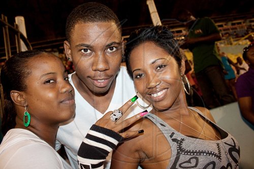 Joined by friends Shawnette Pike (left) and Shantell 'Shanz' Hill, marketing manager for Scikron/Bigyard Music, Sadieki Bolt cheers on big bro Usain, as he does his turn as a footballer at the Bob Marley One Love Charity Celebrity Football Matches and Celebolympics.