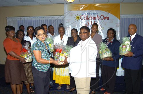 Winston Sill/Freelance Photographer
Shernett Robinson, The Gleaner's Western Bureau Manager, presents a gift basket on behalf of Nestle Jamaica Ltd to Champion Teacher Primrose Swaby.